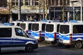 Back view of a German police cars, Mercedes-Benz blue and white painted vans, parked on the pavement and manned by police officers