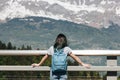 back view of girl with backpack looking at majestic scenic mountains mont