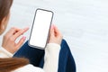 Back view of girl holding smartphone with white blank screen mockup. Lifestyle concept with digital technology Royalty Free Stock Photo