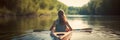 Back view of a girl sailing in a kayak or boat on the river. A girl in a kayak paddles along the river flowing in the Royalty Free Stock Photo