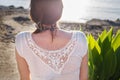 Back view of a girl sitting on sandy beach alone on the sea background close Royalty Free Stock Photo