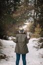 Back view of a girl standing in snowing forest