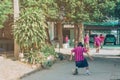 Back view of Girl student wear skirt to practice playing football alone on the street