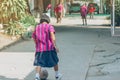 Back view of Girl student wear skirt to practice playing football alone on the street