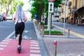 Young woman with colored dreadlocks riding electric scooter Royalty Free Stock Photo