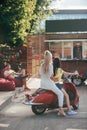 back view of girls sitting on red scooter