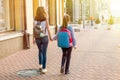 Back view, girls students go to school holding hands.