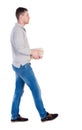 Back view of going handsome man carries a stack of books. Royalty Free Stock Photo