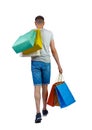 Back view of going man with shopping bags. guy in motion Royalty Free Stock Photo