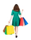 Back view of going woman with shopping bags . beautiful girl i Royalty Free Stock Photo