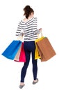 Back view of going woman with shopping bags . beautiful girl i Royalty Free Stock Photo