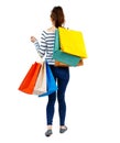 Back view of going woman with shopping bags . Royalty Free Stock Photo