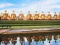 Back view of golden monk statues sitting with water reflection a Royalty Free Stock Photo