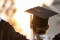 Happy graduated young woman in cap and gown talking with parent in mobile phone and looking certificated in hand so proud Royalty Free Stock Photo