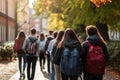 Back view of group of students with backpacks walking in autumn park, Back view of a group of students with backpacks walking on