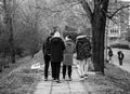 Back view, group of teenagers walking on the alleys of park in Targoviste, Romania, 2020. Black and white photo