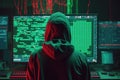 Back view of hacker in a hood with hidden face looks at the monitor screen with glowing code. Hacking and malware concept.