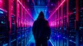 Back view of hacker in hoodie standing among illuminated servers