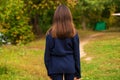 Back view hair brunette girl posing in autumn park