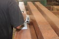 Back view of hands of carpenter using electric planer with wooden plank in carpentry workshop with copy space background. Selectiv