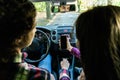 Back view of hands of young couple driving using navigation on mobile phone