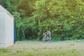 Back view of happiness two brothers wear military camouflage shirts ride bicycle