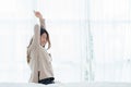 Back view of happy beautiful young Asian woman waking up in morning, sitting on bed, stretching in cozy bedroom. Royalty Free Stock Photo