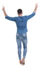 Back view of a happy casual man gesturing peace Royalty Free Stock Photo