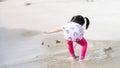 Back view. Happy child was playing and throwing sand into the sea. Children play on the beach.