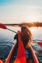 Back view of happy cute girl holding paddle in a kayak on the river Royalty Free Stock Photo