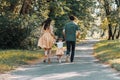 Back view on happy family running on path holding hands and spending time in beautiful green park Royalty Free Stock Photo