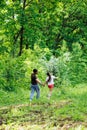 Back view of happy family walking in park forest around green trees, having fun. Little daughter holding hand of father. Royalty Free Stock Photo