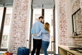 Back view of happy loving couple in hotel room, hugging and standing on window background. Family on vacation, honeymoon Royalty Free Stock Photo