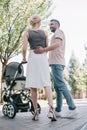 back view of happy parents walking with baby carriage Royalty Free Stock Photo