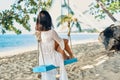 Back view of happy woman relax on swing on beautiful paradises beach Royalty Free Stock Photo