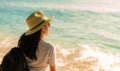 Back view of happy young Asian woman in casual style fashion with straw hat and backpack. Relax and enjoy holiday at tropical Royalty Free Stock Photo