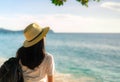 Back view of happy young Asian woman in casual style fashion with straw hat and backpack. Relax and enjoy holiday at tropical Royalty Free Stock Photo