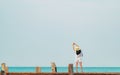 Back view of happy young Asian woman in casual style fashion and straw hat relax and enjoy holiday at tropical paradise beach. Royalty Free Stock Photo