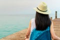 Back view of happy young Asian woman in casual style fashion and straw hat relax and enjoy holiday at tropical paradise beach. Royalty Free Stock Photo