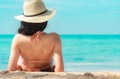 Back view of happy young Asian woman in pink swimsuit and straw hat relax and enjoy holiday at tropical paradise beach at sunset. Royalty Free Stock Photo