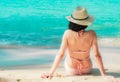 Back view of happy young Asian woman in pink swimsuit and straw hat relax and enjoy holiday at tropical paradise beach at sunset. Royalty Free Stock Photo