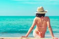 Back view of happy young Asian woman in pink swimsuit and straw hat relax and enjoy holiday at tropical paradise beach at sunset. Royalty Free Stock Photo