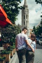 Back view of the happy young couple in love hugging while walking along the street to St. Matthew`s Cathedral in Royalty Free Stock Photo