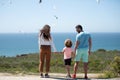 Back view of happy young family walking on beach. Child with parents holding hands. Full length freedom poeple. Royalty Free Stock Photo