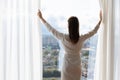 Back view of woman open curtains welcome new day Royalty Free Stock Photo