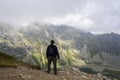 Back view of hiker standing at the edge a cliff the background of rocky mountains and lake in the High Tatras