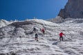 back view of hikers climbing at beautiful snow capped mountains, kyrgyzstan,