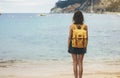 Back view hipster girl with backpack in sand coastline on nature landscape, mock up. Traveler on background beach seascape