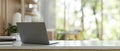 A back view image of a modern workspace in a bright office features a laptop computer on the table Royalty Free Stock Photo