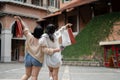 Back view image of two happy Asian female friends are holding their shopping bags, enjoying shopping Royalty Free Stock Photo